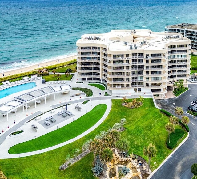 birds eye view of property with a water view and a beach view