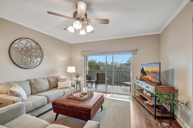 living room featuring wood-type flooring, ornamental molding, and ceiling fan