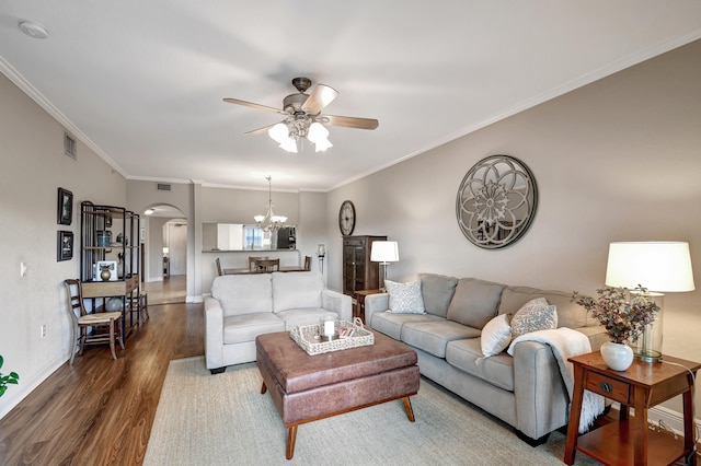 living room featuring hardwood / wood-style floors, ceiling fan with notable chandelier, and ornamental molding