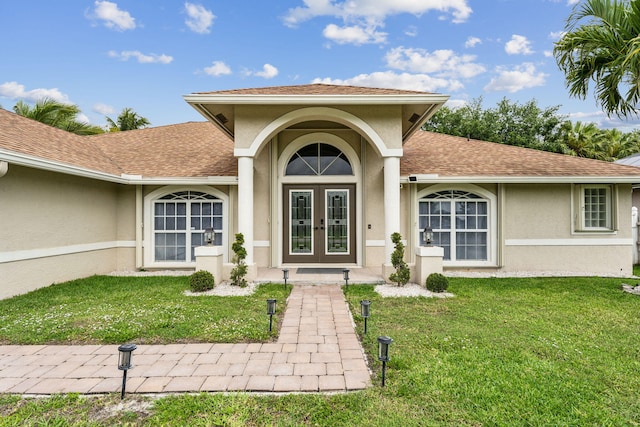 property entrance with a lawn