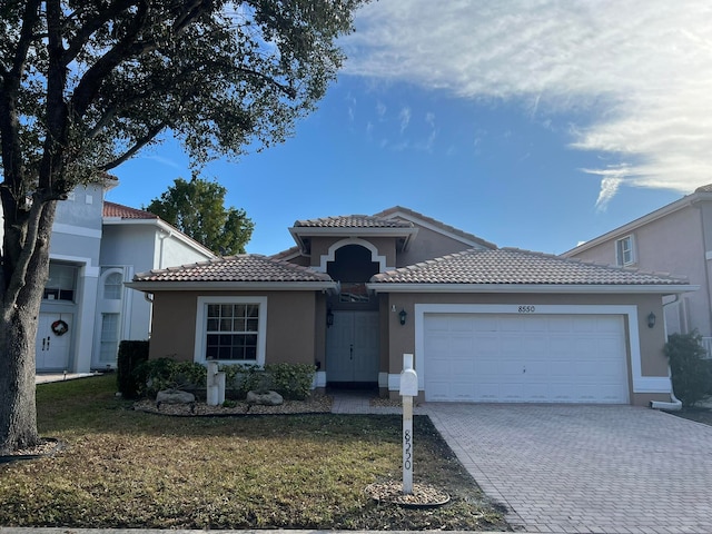 view of front of property with a garage and a front lawn