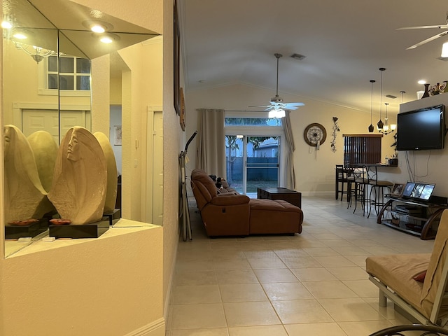 living room featuring ceiling fan, light tile patterned floors, vaulted ceiling, and ornamental molding