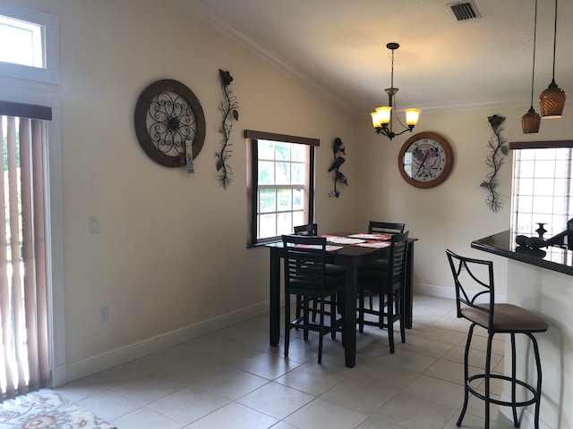 dining space with light tile patterned floors, lofted ceiling, ornamental molding, and a notable chandelier