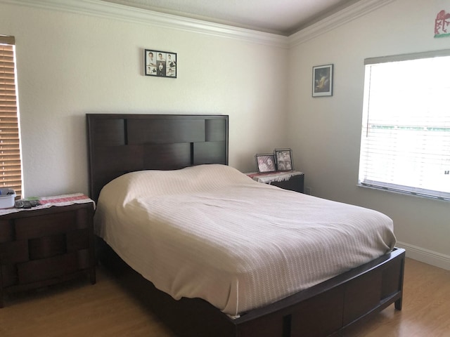 bedroom with light hardwood / wood-style flooring and crown molding