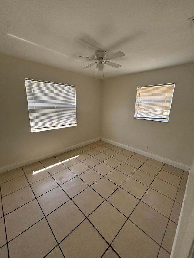 unfurnished room with a ceiling fan, plenty of natural light, and light tile patterned floors
