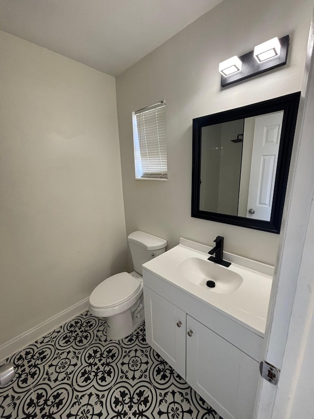 bathroom featuring vanity, baseboards, tile patterned floors, and toilet