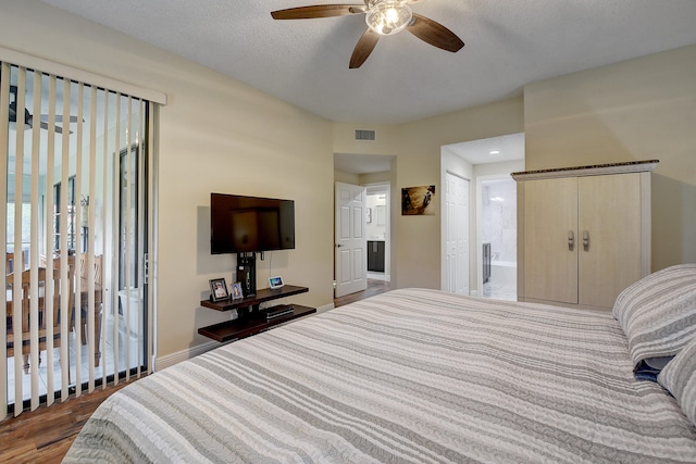 bedroom with connected bathroom, ceiling fan, dark hardwood / wood-style flooring, and a textured ceiling