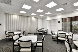 dining space featuring a drop ceiling and dark carpet