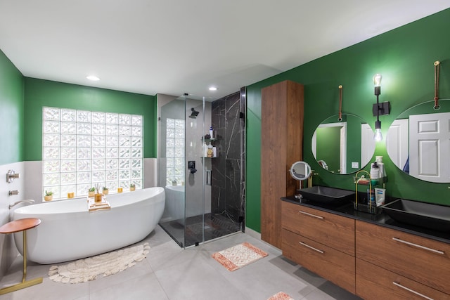 bathroom featuring tile patterned flooring, vanity, and shower with separate bathtub