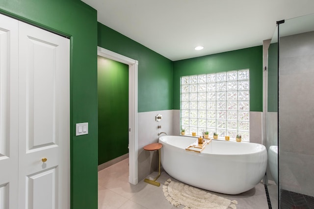 bathroom with tile patterned flooring and a washtub