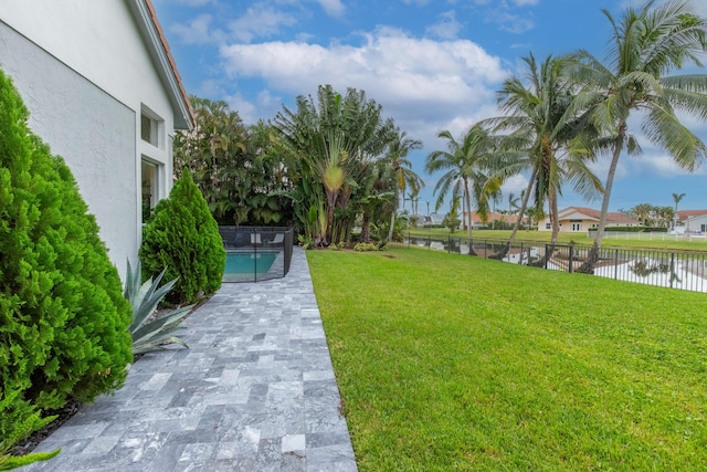 view of yard featuring a water view and a fenced in pool