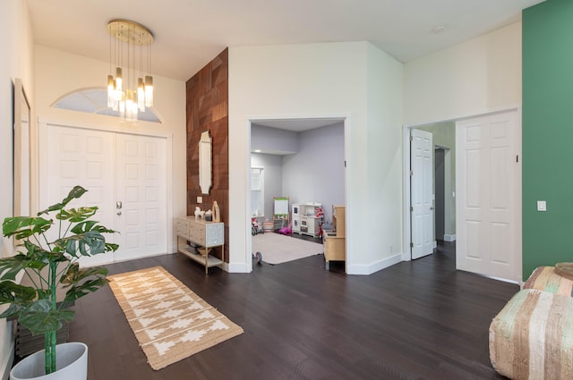 entryway with a chandelier, dark wood-type flooring, and a high ceiling