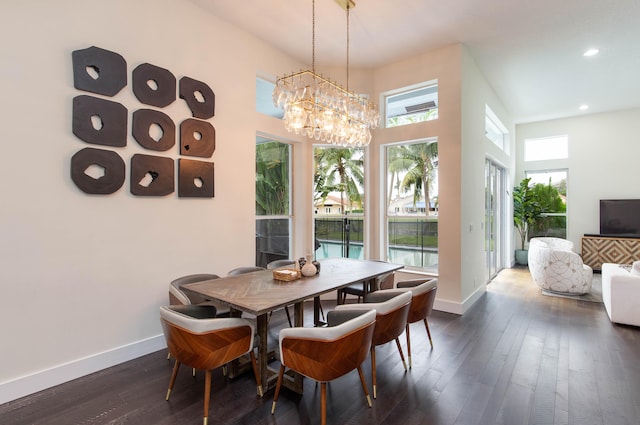 dining space with plenty of natural light, dark hardwood / wood-style flooring, and a chandelier