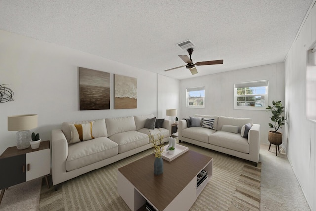 living room featuring ceiling fan, carpet floors, and a textured ceiling