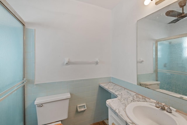 bathroom with vanity, tile walls, walk in shower, and toilet