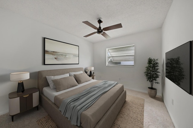 carpeted bedroom with ceiling fan and a textured ceiling