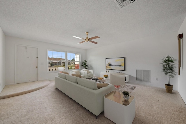 carpeted living room with ceiling fan and a textured ceiling