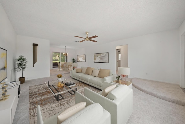 carpeted living room featuring ceiling fan with notable chandelier and a textured ceiling