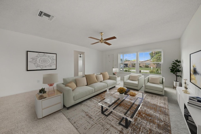 carpeted living room with ceiling fan and a textured ceiling