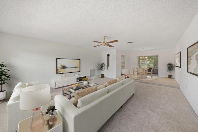 living room with light carpet, ceiling fan with notable chandelier, and a textured ceiling