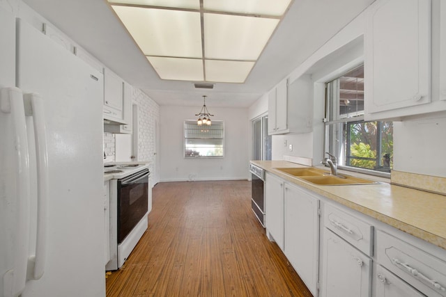 kitchen with white cabinetry, electric range oven, white fridge, a wealth of natural light, and pendant lighting