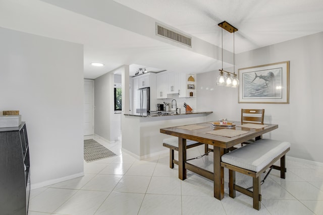 dining area featuring sink, light tile patterned floors, and a notable chandelier