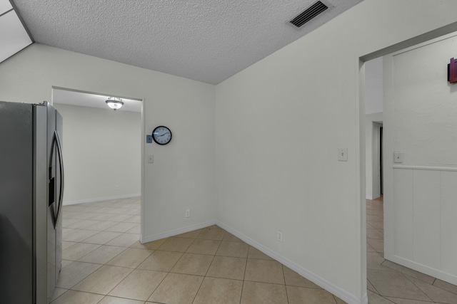 interior space featuring light tile patterned floors and a textured ceiling