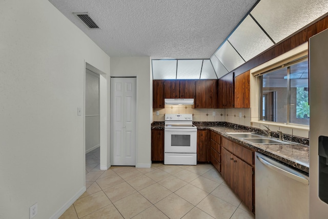 kitchen with decorative backsplash, light tile patterned floors, sink, and appliances with stainless steel finishes