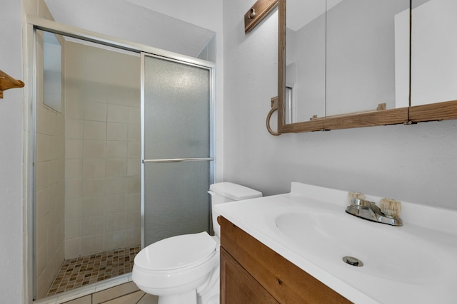 bathroom with tile patterned flooring, vanity, toilet, and a shower with shower door