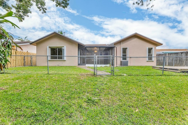 rear view of property featuring a yard and a sunroom