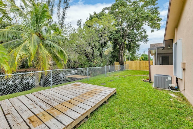 view of yard featuring central AC and a deck