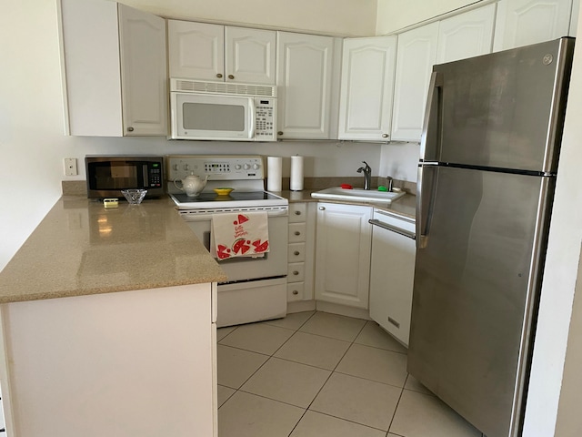 kitchen with sink, light tile patterned floors, white cabinetry, kitchen peninsula, and stainless steel appliances