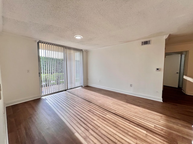 spare room with hardwood / wood-style flooring, crown molding, and a textured ceiling