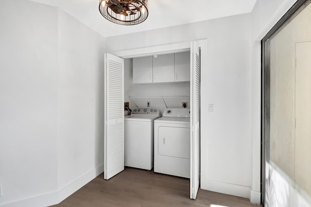 laundry room featuring light wood finished floors, independent washer and dryer, cabinet space, and baseboards