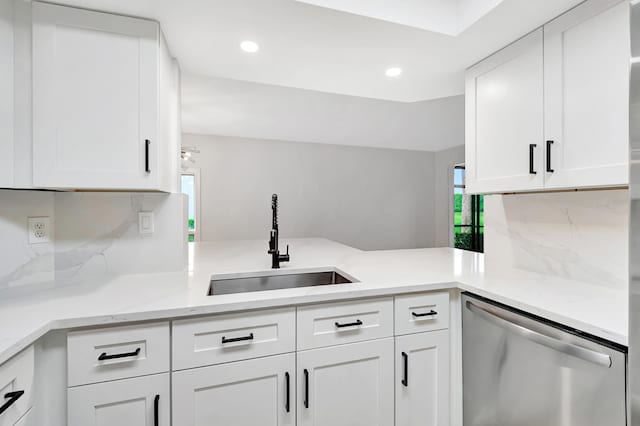 kitchen featuring dishwasher, decorative backsplash, white cabinetry, and sink