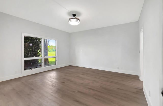 unfurnished room with wood finished floors and baseboards