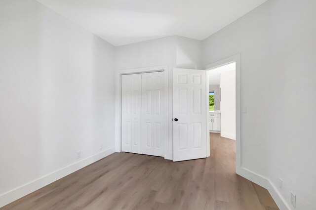 unfurnished bedroom with hardwood / wood-style floors and a closet