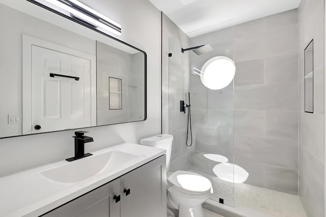 bathroom featuring vanity, toilet, and a shower with shower door