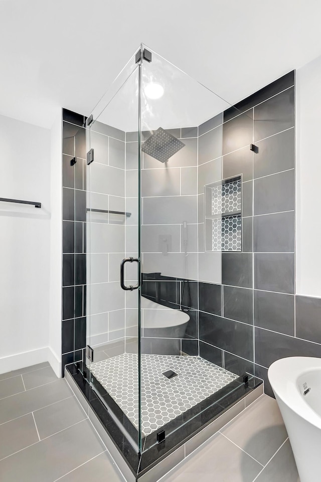 full bath featuring a stall shower, baseboards, and tile patterned floors