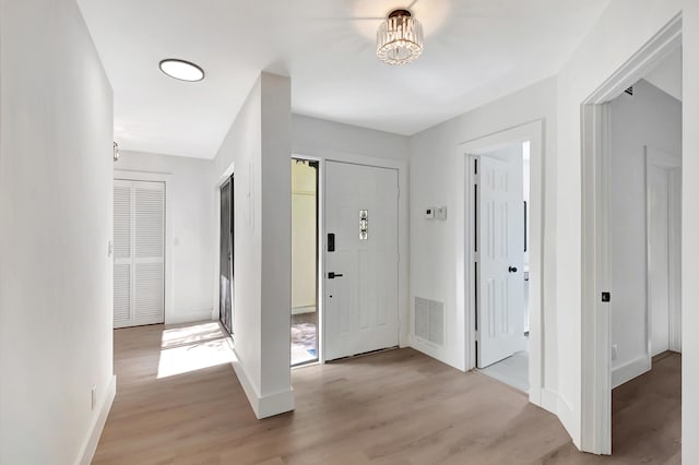 entryway featuring light wood-type flooring, visible vents, and baseboards