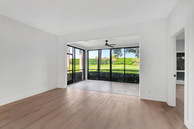 spare room with ceiling fan, baseboards, and wood finished floors