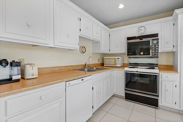 kitchen with a textured ceiling, white cabinets, and white appliances