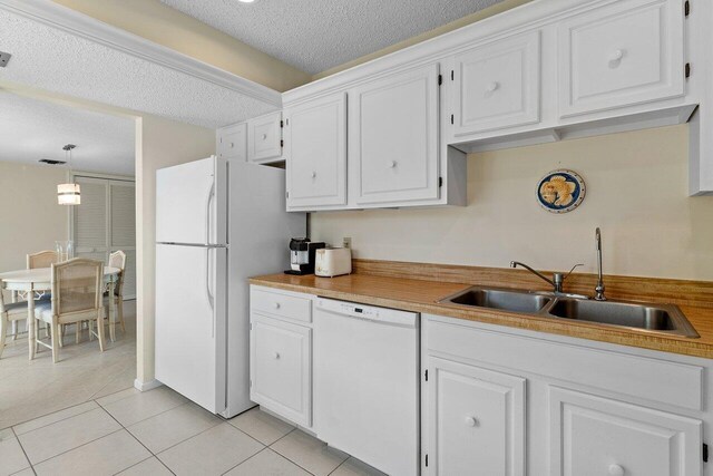 kitchen featuring pendant lighting, white appliances, sink, a textured ceiling, and white cabinetry