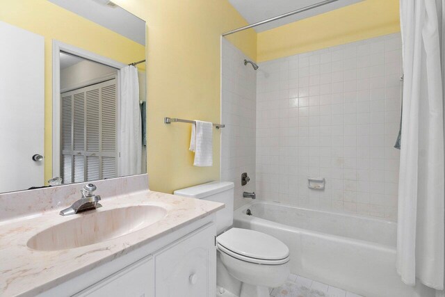 full bathroom with tile patterned flooring, shower / bath combination with curtain, vanity, and toilet