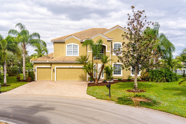 mediterranean / spanish house with a front lawn and a garage