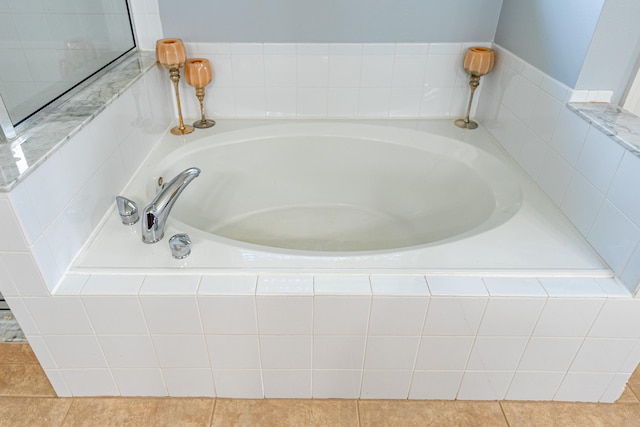 bathroom with tiled bath and tile patterned floors