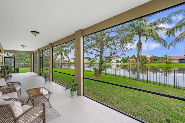 sunroom featuring a water view