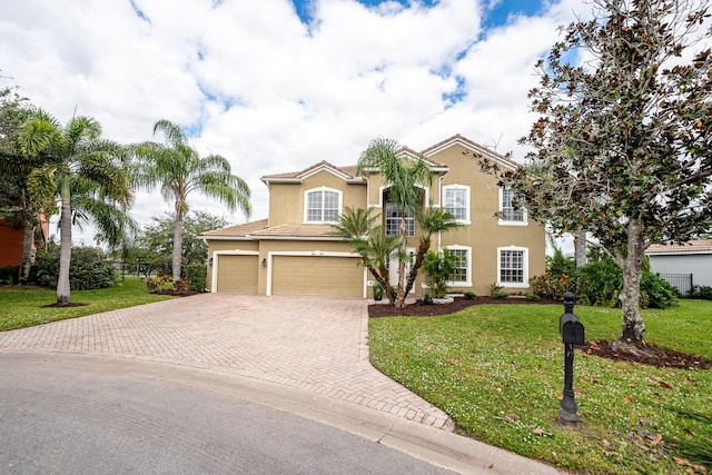 mediterranean / spanish-style home featuring a front yard and a garage