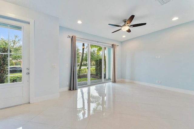 tiled spare room with ceiling fan