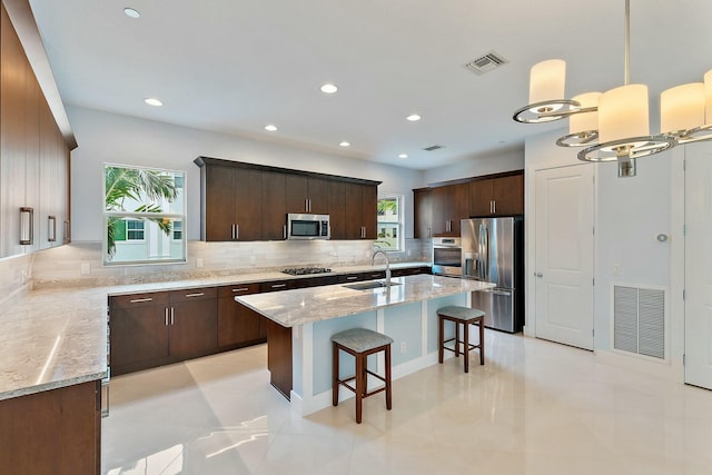 kitchen featuring backsplash, a healthy amount of sunlight, sink, and stainless steel appliances